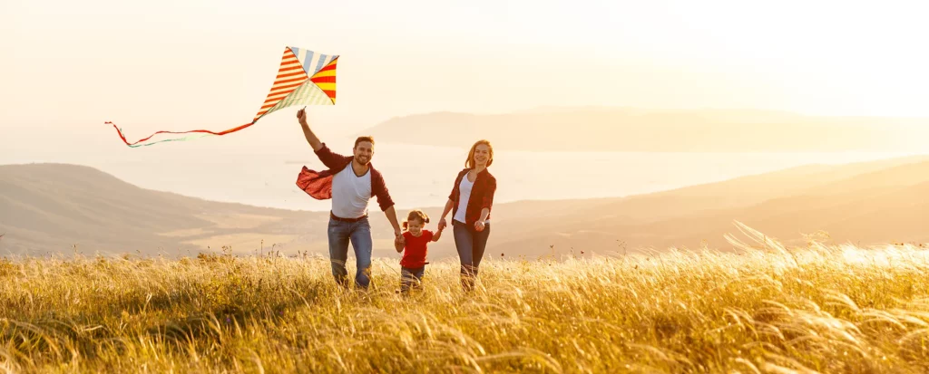 Happy family flying a kite at sunset, reflecting our clinic’s warm, home-like environment.