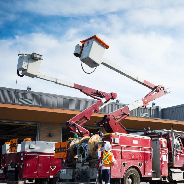greater sudbury hydro bucket truck parked at GSU's building with lineworker driving it